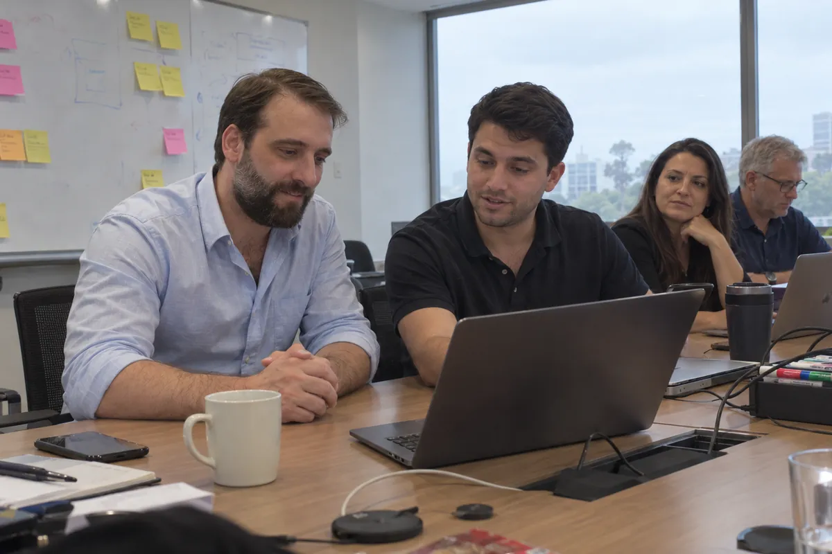 Damien working through an automation with a team member at a laptop